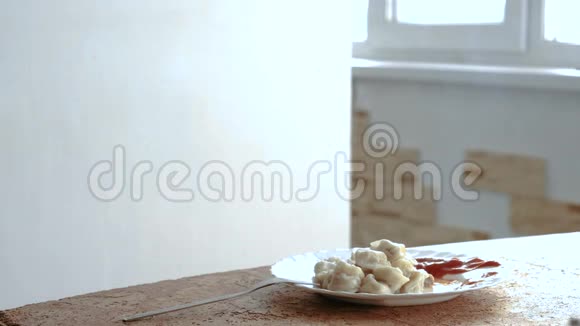 在桌子上的白色盘子里加番茄酱的饺子视频的预览图