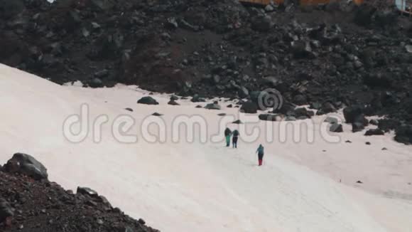 人们登山游客漫步在陡峭的雪山上视频的预览图