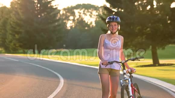 骑自行车在路上行走的年轻女子视频的预览图