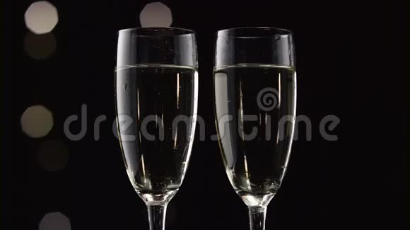 两瓶香槟底部有透明的冰块波克闪烁的黑色背景关门视频的预览图