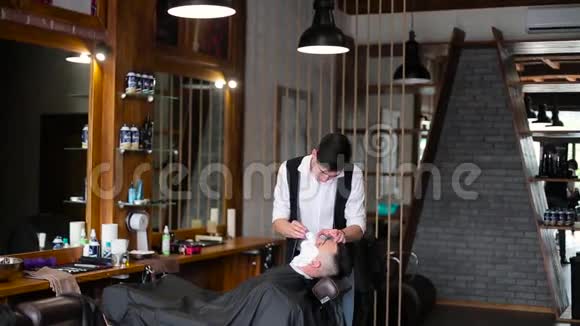 男士在理发店侧视面涂剃须泡沫视频的预览图