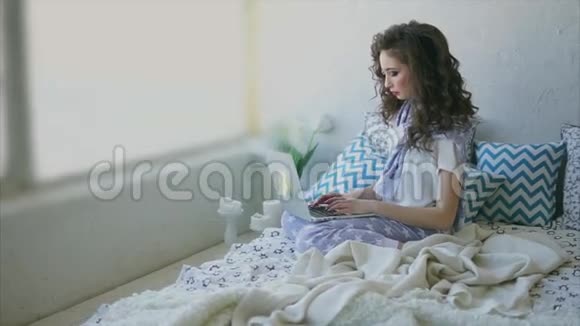 年轻女子在卧室的笔记本电脑上为杂志写文章视频的预览图