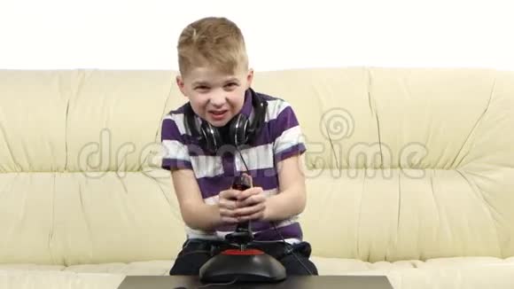 小孩坐在沙发上玩操纵杆视频的预览图