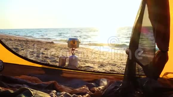 日出时在沙滩上的帐篷附近用烹饪锅做露营炉子视频的预览图