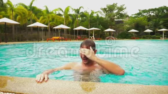 快乐的年轻帅哥跳进游泳池在酒店度假暑假旅游概念视频的预览图