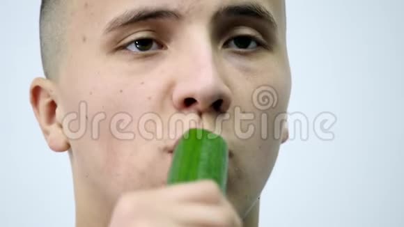 在白色背景下吃黄瓜的年轻人视频的预览图