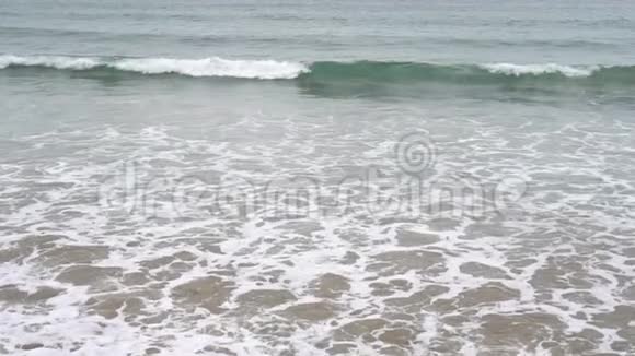 平静的夜晚海洋冲浪泡沫波浪填满了沙滩视频的预览图