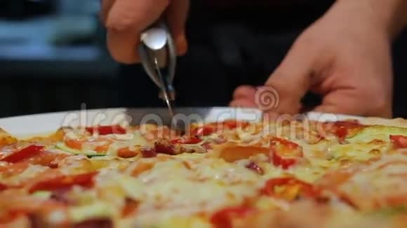 特写人将意大利披萨切成碟片视频的预览图