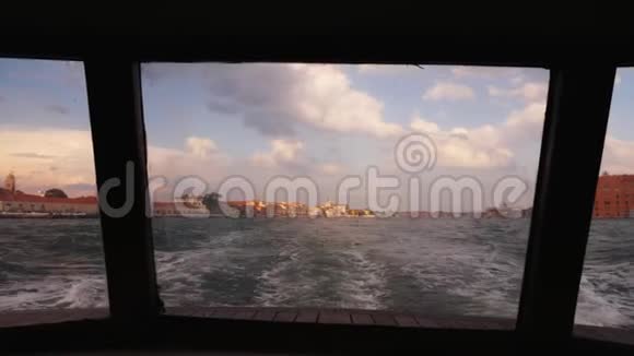 从船尾眺望威尼斯日落时船驶离城市视频的预览图