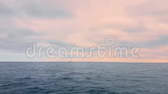 日落时粉红色云朵背景上的海景视频的预览图