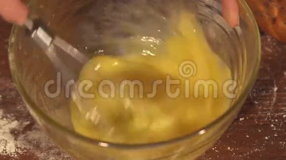女孩用打蛋器把鸡蛋倒在碗里视频的预览图