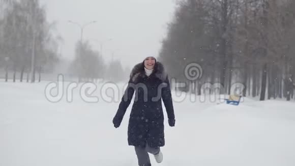 一个冬天公园里的布鲁内特女人在露天漫步视频的预览图