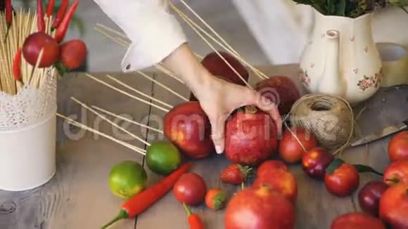 女厨师从木桌上取出石榴在烹饪前准备水果和蔬菜视频的预览图