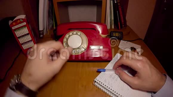 一个男人在用旧的红色电话视频的预览图