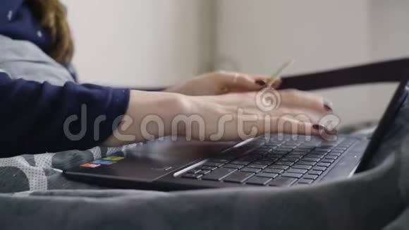 近距离拍摄年轻女性在笔记本电脑上从互联网上购买商品视频的预览图