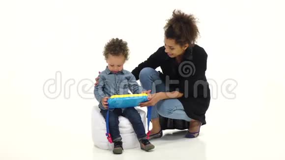 美国黑人母亲给她的孩子一个有趣的玩具白色背景慢动作视频的预览图