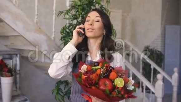 厨师女花匠打电话给她的客户配花和水果混合花束视频的预览图