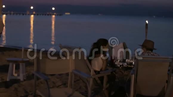 希腊海滩上浪漫晚餐的年轻幸福夫妇视频的预览图