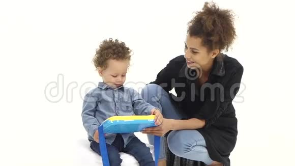 美国黑人母亲给她的孩子一个有趣的玩具白色背景慢动作视频的预览图