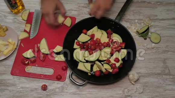 俯视图白色木桌上准备的大蒜祖奇尼和西红柿樱桃的素食视频的预览图