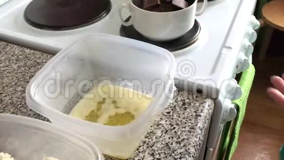 一个女人在一个容器里加入了干酪里面有融化的黄油香草和糖粉甜点的配料视频的预览图