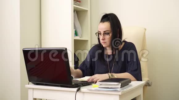这位戴眼镜的妇女在工作日看电脑显示器视频的预览图
