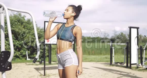 运动型女孩锻炼时喝酒视频的预览图