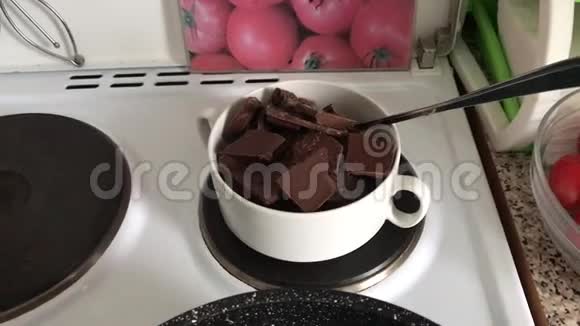在炉子上的碗里放了一块黑白巧克力巧克力被融化在水浴中做甜点视频的预览图