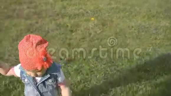 小女孩在公园的绿草上奔跑视频的预览图