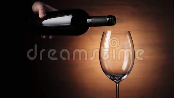 豪华红酒在棕色背景下用手从酒瓶里倒出美味的葡萄酒玫瑰酒视频的预览图