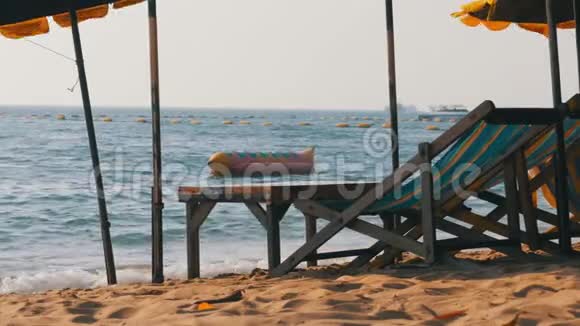 木制阳光床与伞在沙滩对海泰国芭堤雅视频的预览图