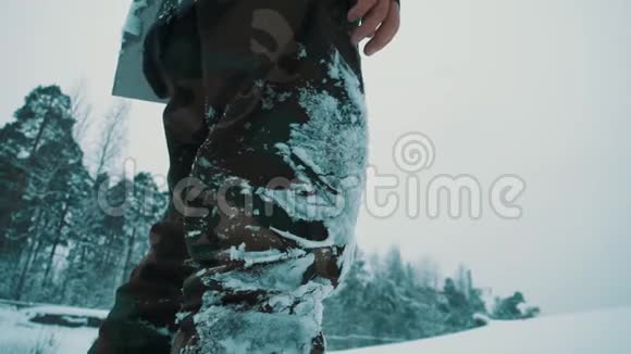 冬季白天人们在野外用膝盖扫雪视频的预览图