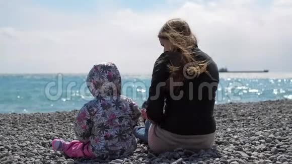 春天的时候妈妈和可爱的粉红色小女孩在海滩上玩耍视频的预览图