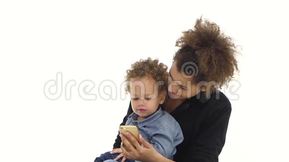 非裔美国人的母亲和她的孩子坐在一起拿着一部电话白色背景慢动作视频的预览图