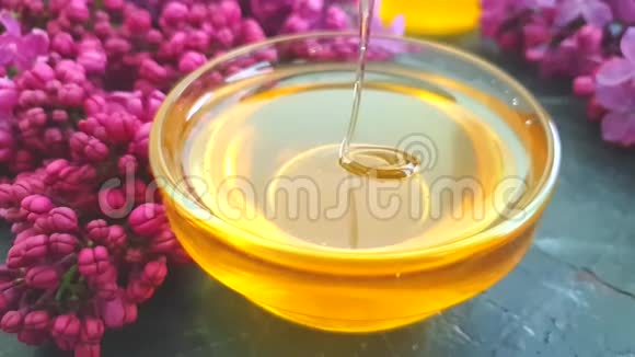 蜂蜜紫丁香香花慢动作黑色混凝土背景营养成分视频的预览图