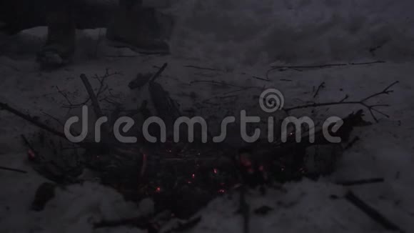 踩着燃烧的篝火灰烬和煤的靴子脚视频的预览图
