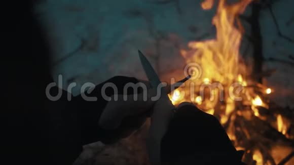 男性用刀刀在篝火上削铅笔视频的预览图