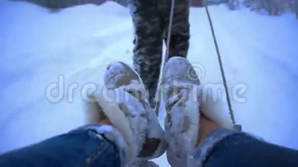 男人把女孩卷在雪地里的雪橇上视频的预览图