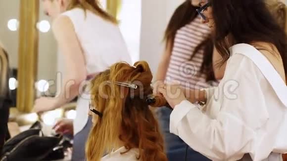 主人试着换个发型理发师为一个女孩的专业摄影做头发视频的预览图