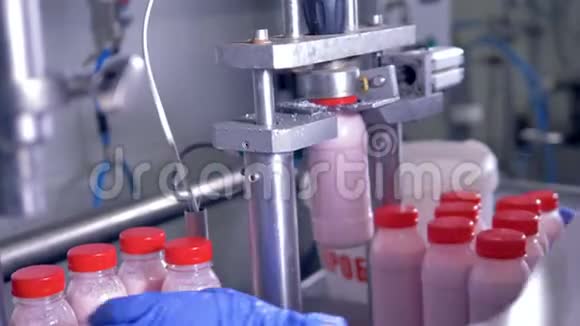 将装有粉红色酸奶的瓶子放入封口机视频的预览图
