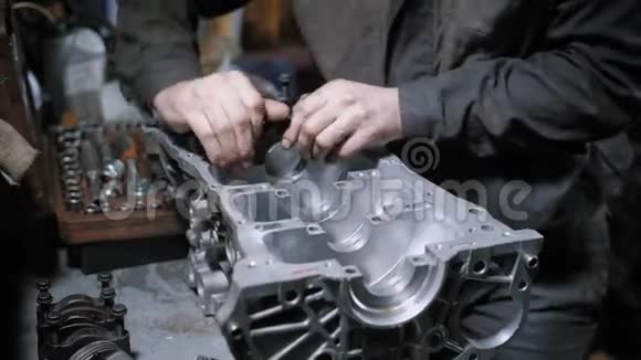 汽车维修中心一名专业机械师拆卸发动机缸体的特写镜头视频的预览图