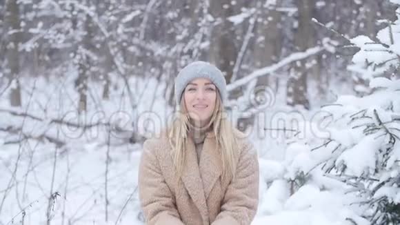 冬天的乐趣女人在冬天的森林或公园里向空中撒雪视频的预览图