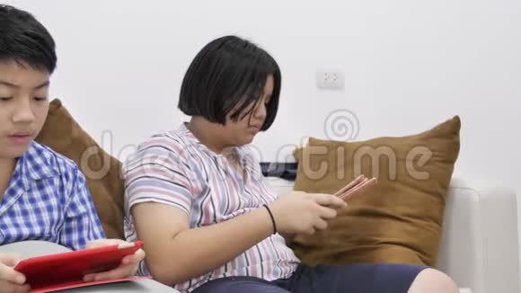 快乐的亚洲男孩和女孩一起在平板电脑上玩游戏面带笑容4K视频的预览图