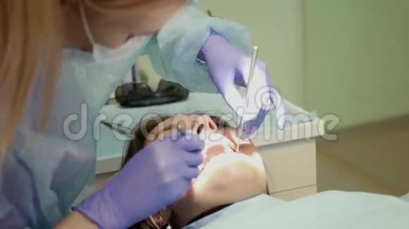 一位女牙医给病人检查口腔使用特殊的工具4k3840x2160视频的预览图