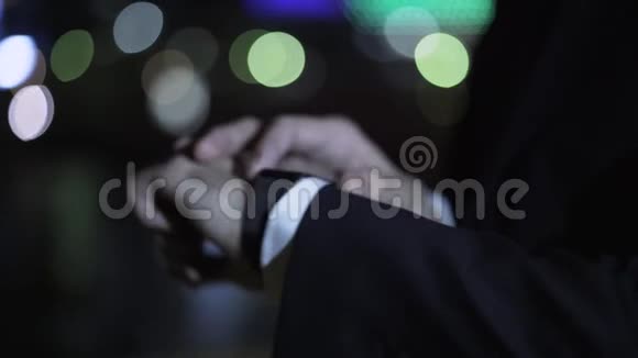 在一条夜街上用智能手表把商人的手收起来视频的预览图