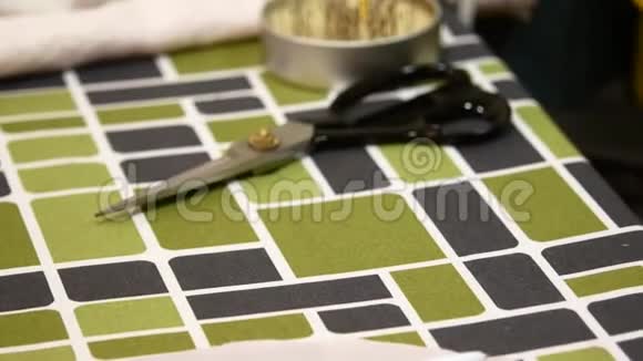 缝纫厂剪刀和针在切刀桌子上视频的预览图