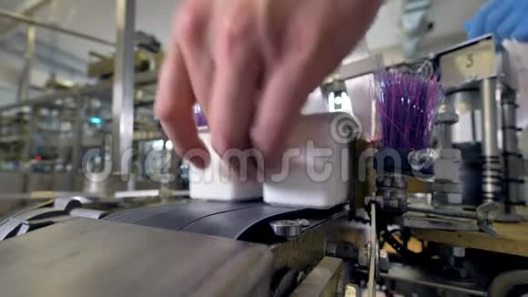 工人们用手从自动传送机上取出酸乳包装视频的预览图