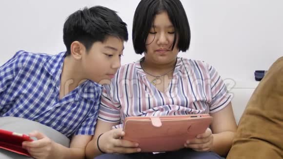 快乐的亚洲男孩和女孩一起在平板电脑上玩游戏面带笑容4K视频的预览图