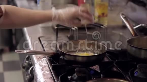 在厨房里厨师在意大利面上加一个生鸡蛋肉放在燃烧的炉子上视频的预览图