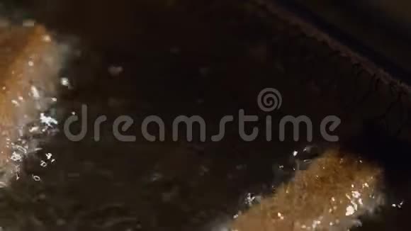 在深油炸锅中准备啤酒零食炸面包饼的特写视频的预览图